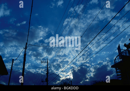 Electricity pylons under a cloudy twilight sky Stock Photo