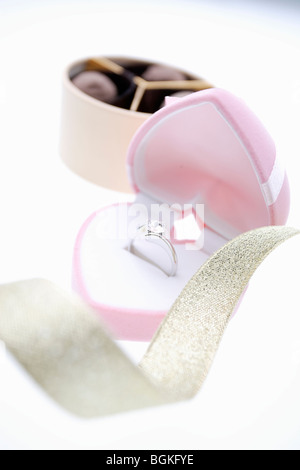 Diamond ring in a heart shaped box and a box of chocolates Stock Photo