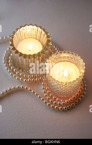 Tealight candles in glass holders with pearl necklace Stock Photo