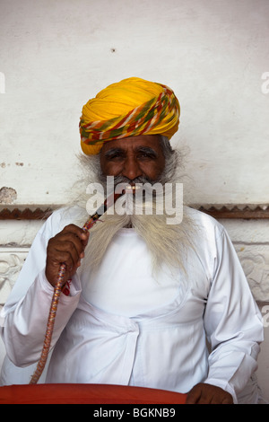 Indian man wearing turban smoking pipe in the Mehrangarh Fort, Jodhpur, Rajasthan, northern India, Asia Stock Photo