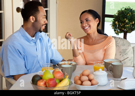 A happy African American man and woman couple in their thirties sitting outside having a healthy breakfast Stock Photo