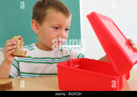 Young boy looks in lunch box Stock Photo
