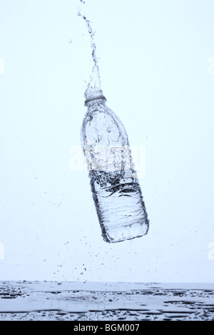 Bottle of water bouncing off surface and splashing Stock Photo