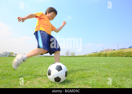 Young boy kicking soccer ball on field. Futako-tamagawa Setagaya-ku Tokyo Prefecture Japan Stock Photo