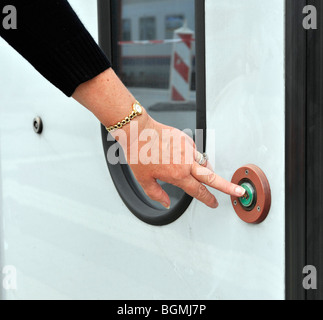 European woman pressing the door release on Luxembourg commuter train. Stock Photo