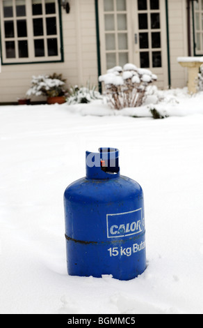 Butane cylinder bottle standing in snow during Winter.Home heating Stock Photo