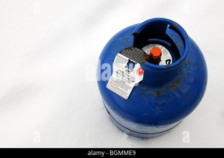 Butane cylinder bottle standing in snow with a free heater health check notice attached Stock Photo