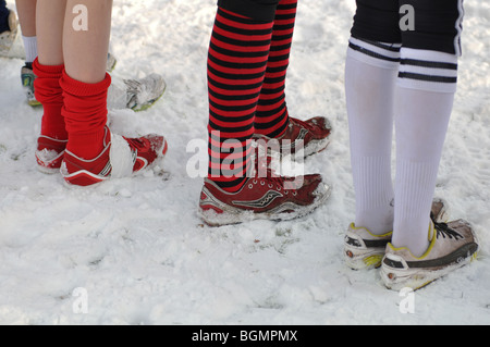 Teenage girls on start line of cross-country running race standing in snow