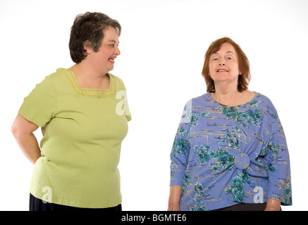 An senior retired elderly woman stands with a middle aged woman. Stock Photo