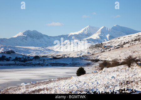 Llynnau Mymbyr frozen lakes & Snowdon horseshoe in Snowdonia National Park with snow in winter light. Capel Curig, North Wales, UK. Stock Photo