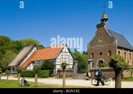 Rural constable and farmer in traditional costume in front of chapel, open air museum Bokrijk, Belgium Stock Photo