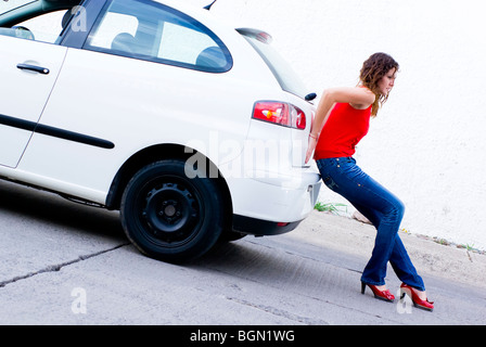 woman pushing car out of gasoline Stock Photo