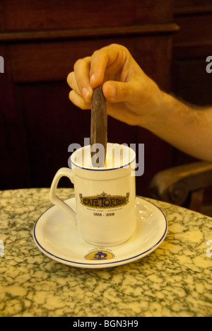 Close-up of person dipping chocolate in hot chocolate at Cafe Tortoni in Buenos Aires, Argentina Stock Photo