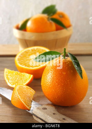 Fresh oranges whole and cut halves with leaves Stock Photo