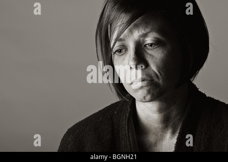 Dramatic Low Key Shot of an Upset 30s Lady in Dressing Gown Stock Photo