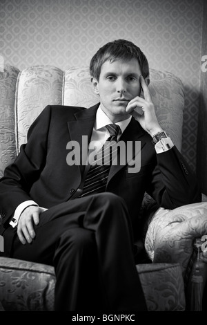 Young businessman on a chair. Black and white. Stock Photo