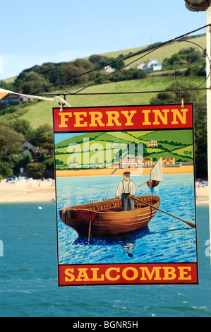 The Ferry Inn sign at Salcombe which shows scenery similar to the background in the photo. Stock Photo