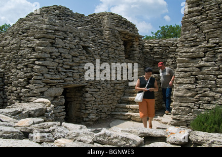Tourists visiting the restored village des Bories with its traditional stone Gallic huts, Gordes, Vaucluse, Provence, France Stock Photo
