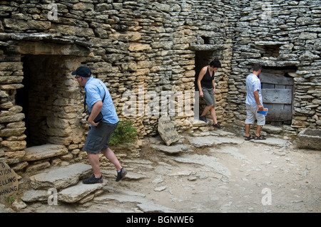 Tourists visiting the restored village des Bories with its traditional stone Gallic huts, Gordes, Vaucluse, Provence, France Stock Photo