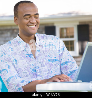 Mid adult man using a laptop and smiling Stock Photo