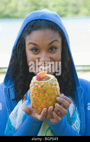 Portrait of a young woman holding a pineapple and smiling Stock Photo