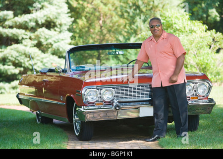 Senior man leaning against a convertible car Stock Photo
