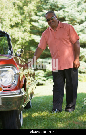 Senior man opening a door of a car and smiling Stock Photo