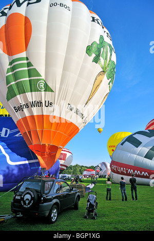 Balloonists / Aeronauts inflating hot-air balloon with propane burner during hot air ballooning meeting Stock Photo
