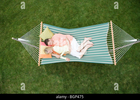 High angle view of a mid adult woman sleeping with a mature man in a hammock Stock Photo