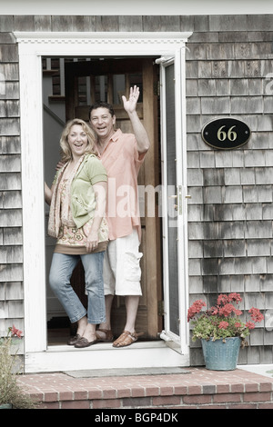Portrait of a mature couple standing at the door of a house Stock Photo