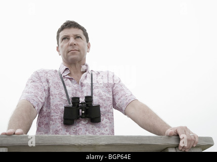 Low angle view of a mature man leaning against a railing Stock Photo
