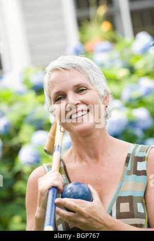 Portrait of a mature woman holding a croquet mallet and a ball Stock Photo