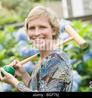 Portrait of a mature woman holding a croquet mallet and a ball Stock Photo