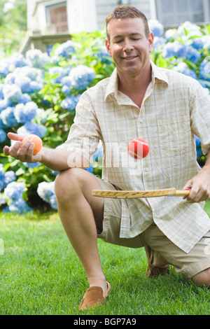 Close-up of a mature man holding a tennis racket and a ball Stock Photo