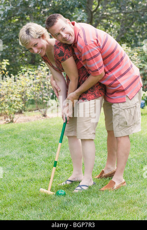 Mature couple playing croquet in a lawn Stock Photo