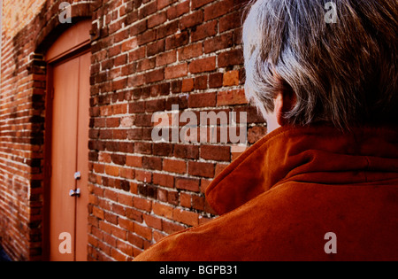 lonely woman by brick wall Stock Photo