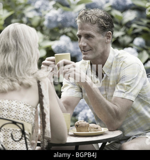 Mature couple having tea in a lawn Stock Photo