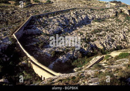 The wall that divides Malta and is called Victoria Lines snakes down a valley gorge near Madliena. Stock Photo