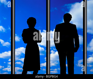 couple looking at clouds through large glass window Stock Photo