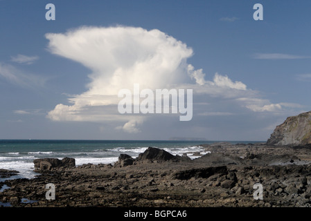 Nimbus cloud over rocks at marsland mouth on the devon cornwall border Stock Photo