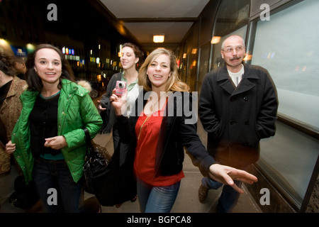 Three daughters and a father walk down the downtown sidewalk at night. Stock Photo