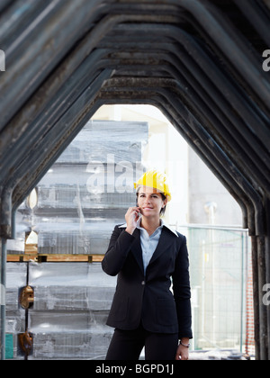 female engineer talking on mobile phone in construction site Stock Photo