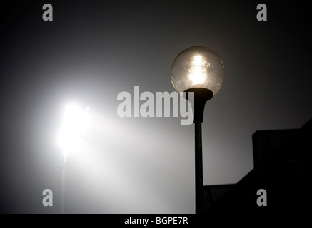 Lit stadium lights and streetlamp at night on fog , Finland Stock Photo