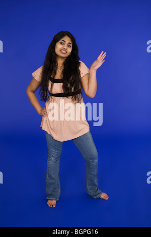 East Indian teenage girl posing on blue background with some attitude Stock Photo