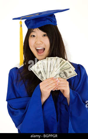 An Asian teenage in blue graduation gown and smiling while hold US money to illustrate to high cost of education. Stock Photo