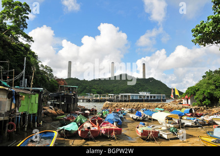 Stilt dwellings of Lamma fisherfolk, looking towards the stacks of Lamma Power Station, Yung Shue Wan, Lamma Island, Hong Kong Stock Photo