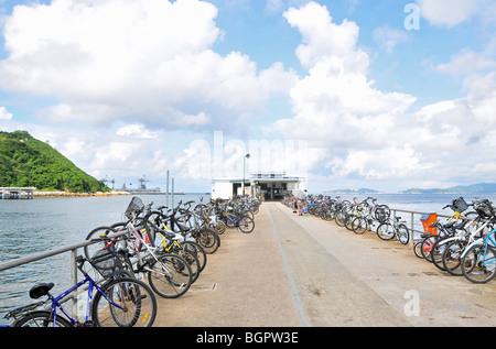 Bicycle-lined ferry terminal jetty, looking seawards, Yung Shue Wan (Banyan Tree Bay), Lamma Island, Hong Kong, China Stock Photo