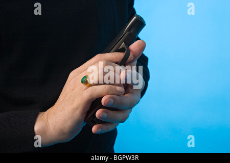 black and white close-up shot of man's hands with pistol Stock Photo