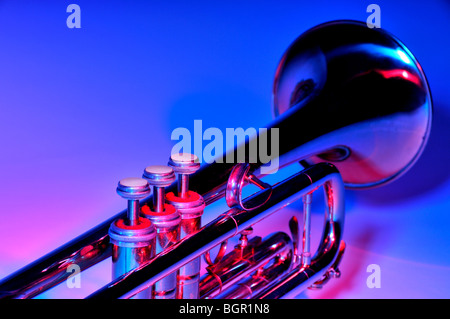 Trumpet under coloured lighting showing a closeup of the valves with the bell in the distance. Stock Photo