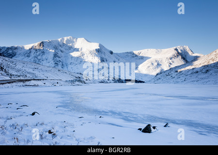 Ogwen Valley, North Wales, UK. View across frozen Llyn Ogwen lake to Y Garn with snow covered mountains in winter Stock Photo
